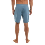 Blue beach shorts worn by a person on a white background