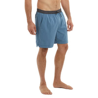 Man wearing blue swim shorts on a white background