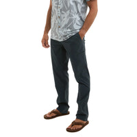 Person wearing dark pants and a patterned shirt on a white background