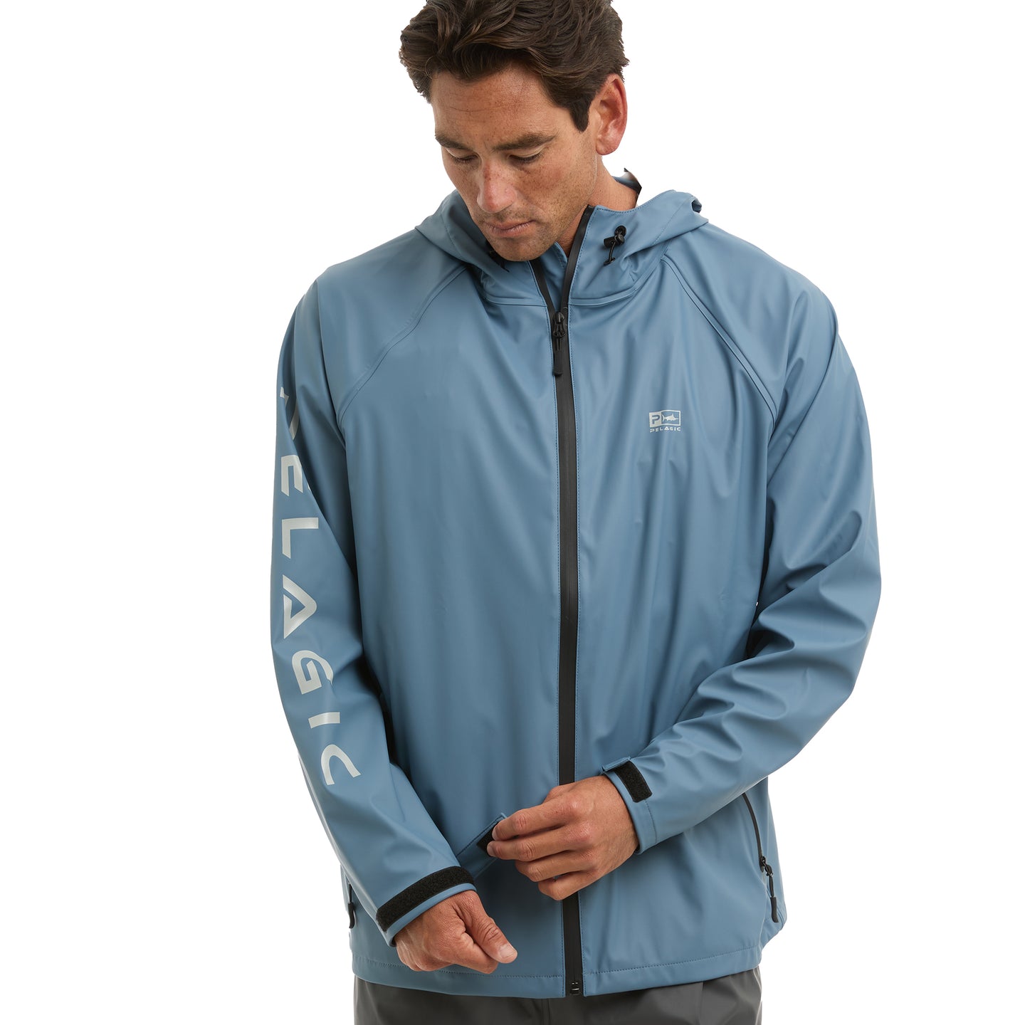 Man wearing a blue rain jacket with 'Pelagic' branding on a white background