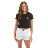 Woman wearing a black t-shirt with a logo and white shorts on a white background